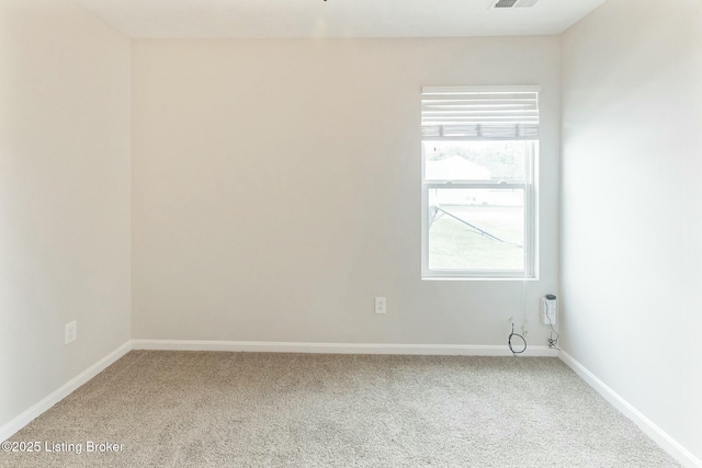 carpeted spare room featuring visible vents and baseboards