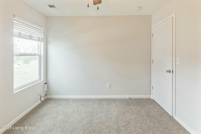 carpeted empty room with visible vents, baseboards, and a healthy amount of sunlight