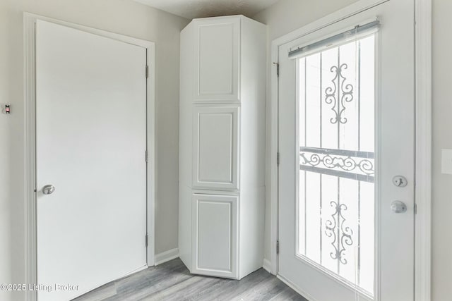 entrance foyer with light wood-style flooring and baseboards