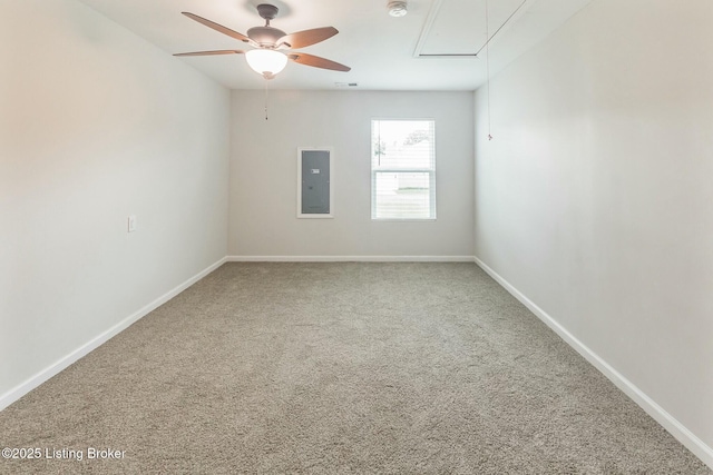unfurnished room with a ceiling fan, attic access, carpet, and electric panel