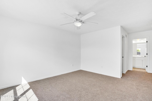 empty room with light colored carpet, ceiling fan, and baseboards