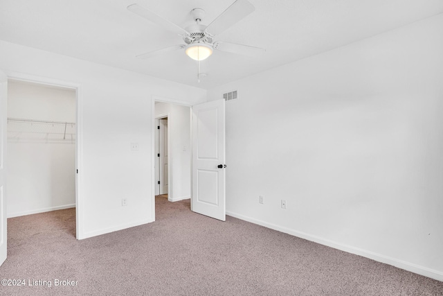 unfurnished bedroom featuring baseboards, a closet, a spacious closet, carpet floors, and visible vents