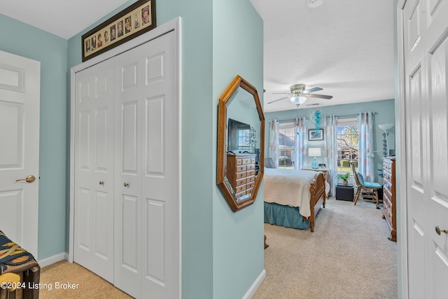 carpeted bedroom with ceiling fan, baseboards, and a closet