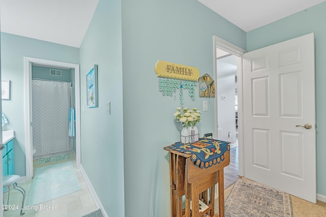 hall with baseboards and visible vents