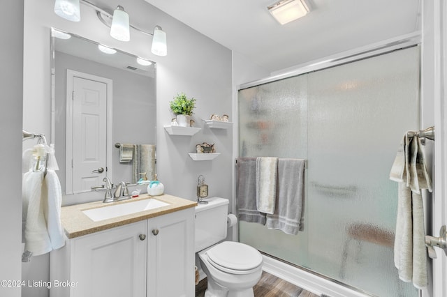 full bathroom featuring wood finished floors, visible vents, toilet, vanity, and a stall shower