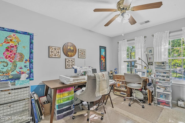 carpeted office space with visible vents and a ceiling fan