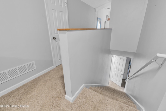 stairway featuring baseboards, carpet flooring, and visible vents