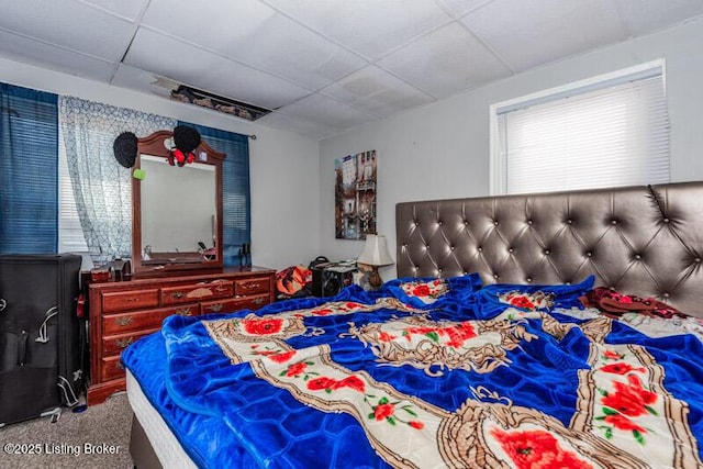 carpeted bedroom with a paneled ceiling