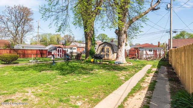 view of yard featuring an outdoor structure, a shed, and a fenced backyard