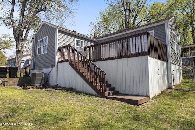 rear view of house featuring central AC, a wooden deck, stairway, and a yard
