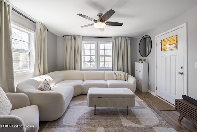 living room with a wealth of natural light, a ceiling fan, wood finished floors, and baseboards