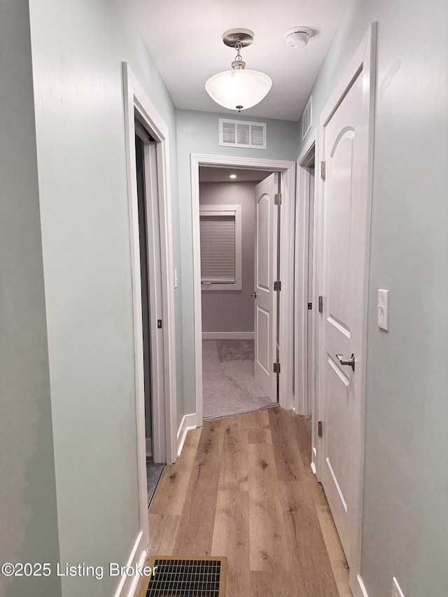 hall featuring light wood-style floors and visible vents