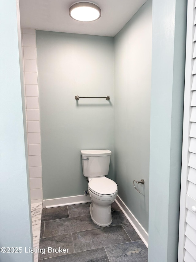 bathroom featuring baseboards and toilet