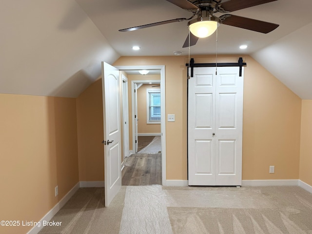 additional living space featuring lofted ceiling, light carpet, and a ceiling fan