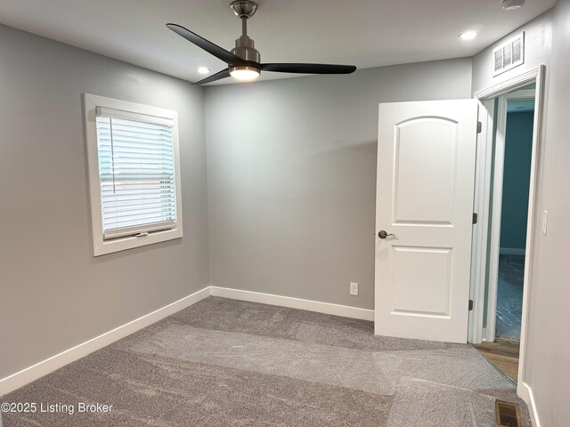 carpeted empty room featuring baseboards, a ceiling fan, visible vents, and recessed lighting