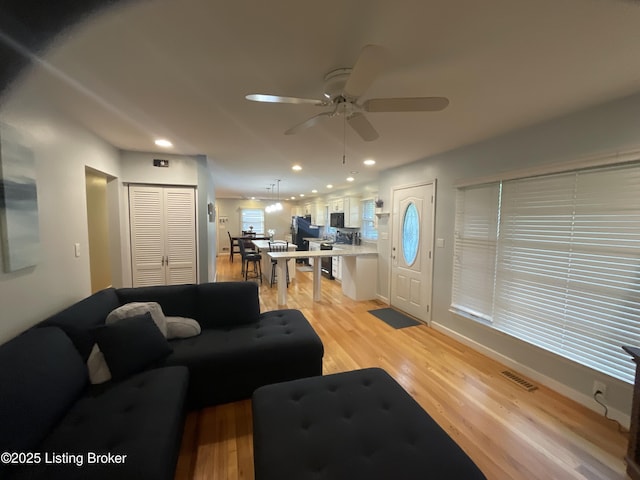 living area featuring recessed lighting, light wood finished floors, visible vents, and a ceiling fan