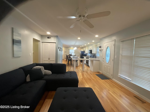 living room with recessed lighting, light wood-type flooring, visible vents, and ceiling fan
