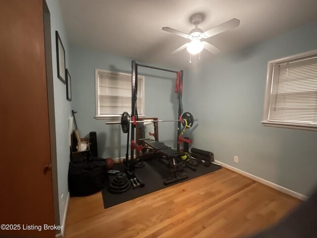 exercise room with ceiling fan, baseboards, and wood finished floors
