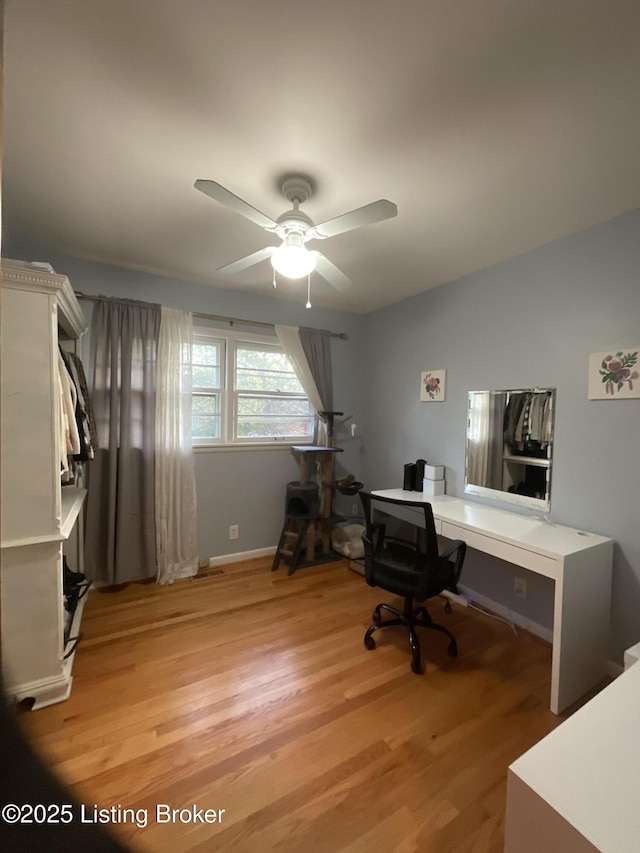 office space featuring ceiling fan, baseboards, and light wood-style floors