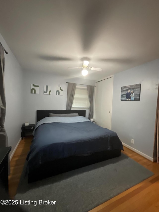 bedroom with baseboards, a ceiling fan, and wood finished floors