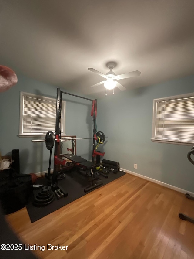 workout room featuring baseboards, a ceiling fan, and wood finished floors