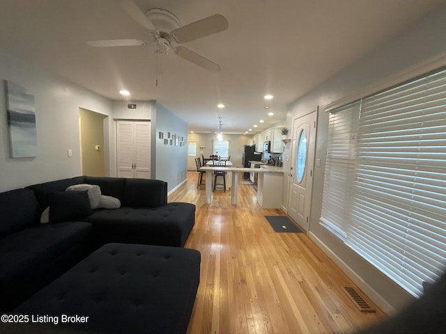 living area with a ceiling fan, visible vents, recessed lighting, and light wood-style floors