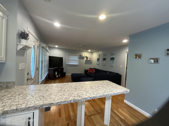 kitchen with dark wood finished floors, white cabinetry, light countertops, and recessed lighting