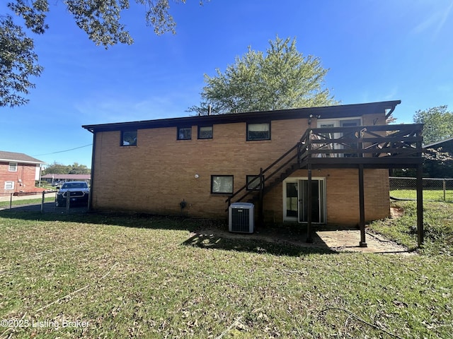 rear view of property featuring stairway, fence, central AC, a wooden deck, and a lawn