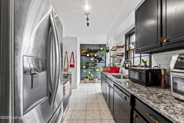 kitchen with open shelves, a sink, black appliances, decorative backsplash, and light stone countertops