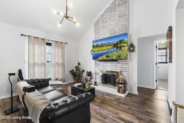 living room featuring wood finished floors, a fireplace, baseboards, a chandelier, and high vaulted ceiling