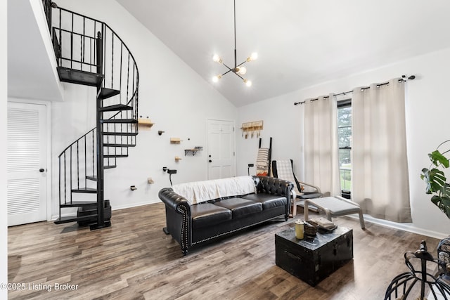 living room featuring baseboards, a notable chandelier, wood finished floors, stairway, and high vaulted ceiling