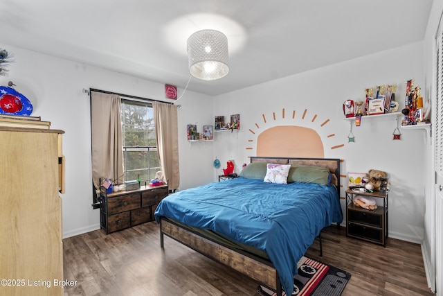 bedroom with baseboards and wood finished floors