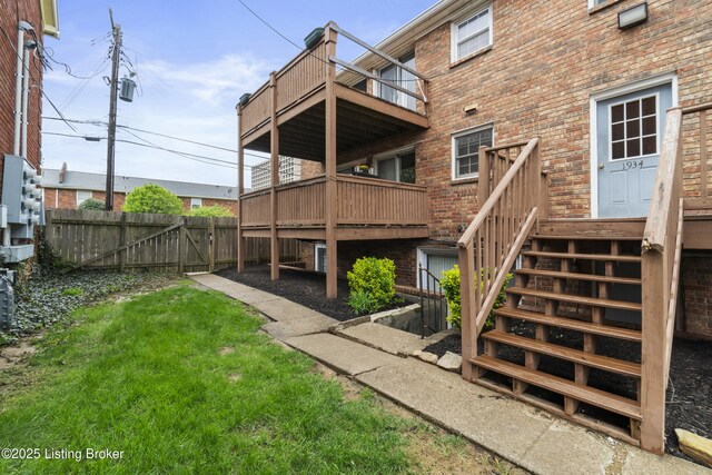 back of property featuring brick siding, fence, and a balcony