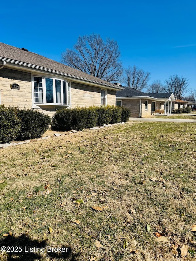 view of side of property with a lawn and a garage
