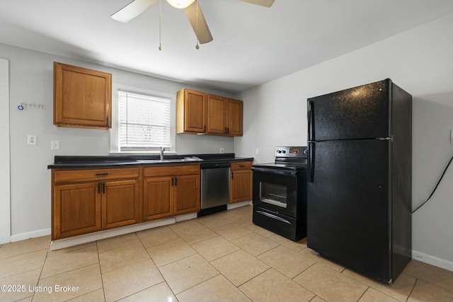 kitchen with dark countertops, a sink, brown cabinetry, black appliances, and ceiling fan
