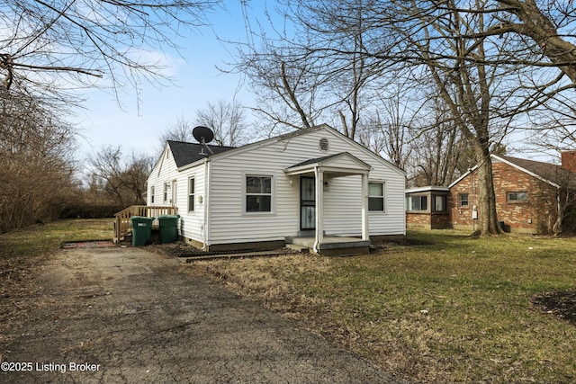 bungalow featuring aphalt driveway and a front yard