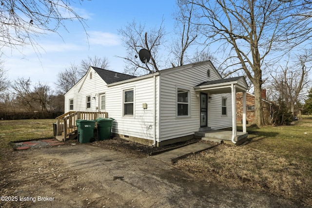 view of side of home featuring a yard and crawl space