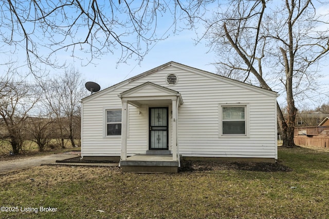 view of front of house featuring fence and a front lawn