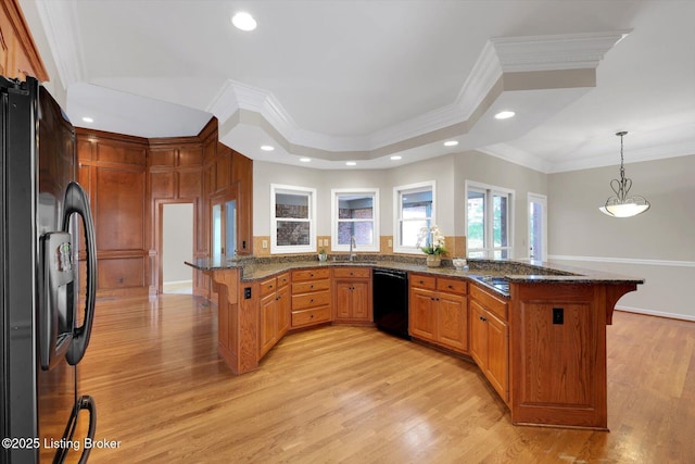 kitchen featuring a peninsula, crown molding, a sink, and black appliances