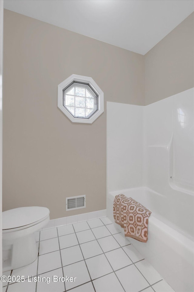 bathroom with tile patterned floors, a bathtub, toilet, baseboards, and visible vents