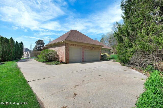 view of property exterior featuring brick siding, an attached garage, concrete driveway, and roof with shingles