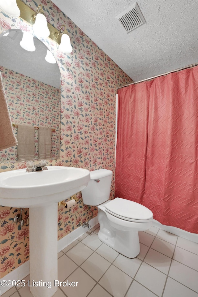 bathroom featuring tile patterned flooring, wallpapered walls, and visible vents