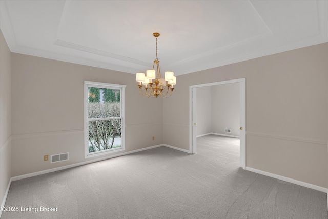 spare room featuring a chandelier, carpet floors, a tray ceiling, baseboards, and visible vents