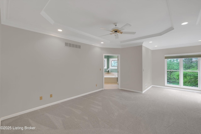 empty room featuring visible vents, recessed lighting, a ceiling fan, crown molding, and a raised ceiling