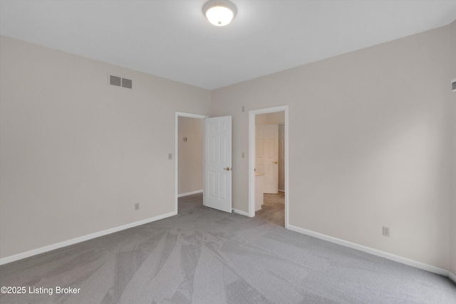 empty room with baseboards, visible vents, and carpet
