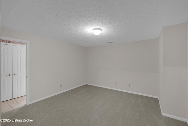 unfurnished room featuring visible vents, baseboards, carpet flooring, and a textured ceiling