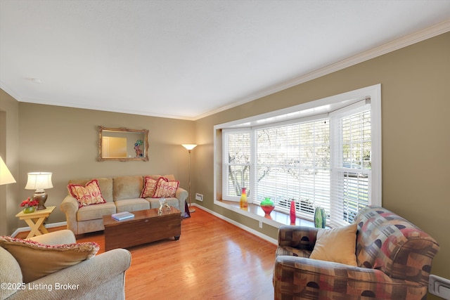 living room featuring light wood finished floors, baseboards, and ornamental molding
