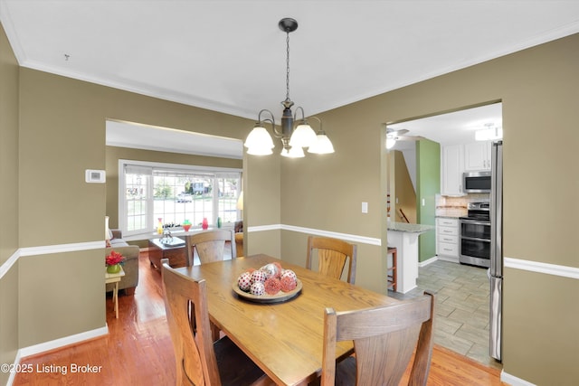 dining space with crown molding and a chandelier