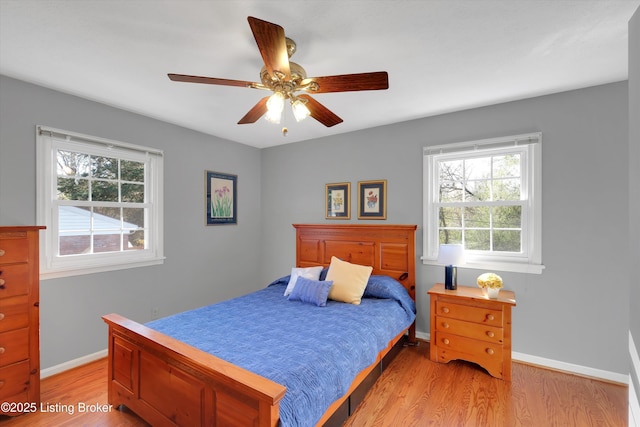 bedroom with light wood-style floors, a ceiling fan, and baseboards
