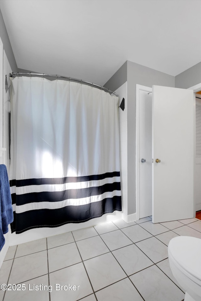 full bathroom featuring curtained shower, tile patterned flooring, and toilet